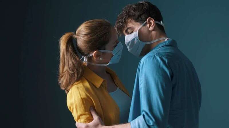 Beso de una pareja con mascarilla (Foto TA)